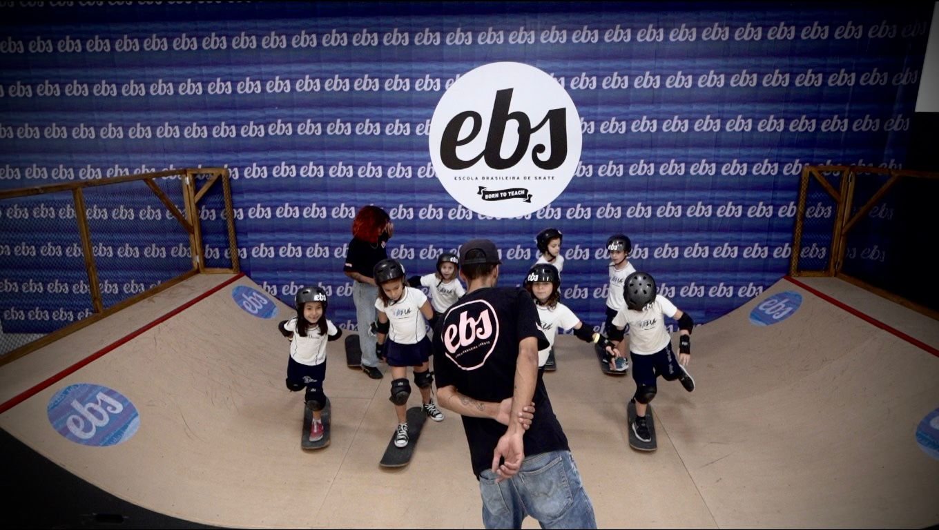 Aluno em aula de skate com instrutor da EBS