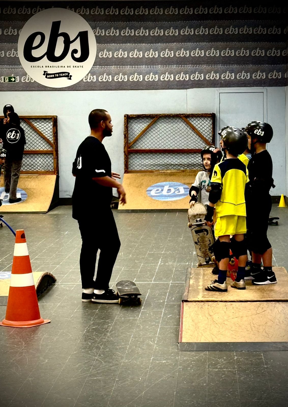 Aluno praticando skate com equipamentos de segurança